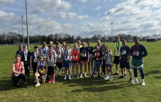 Runners and walkers showing off their medals from the 2024 Three Rivers Promise Run For The Future 5K