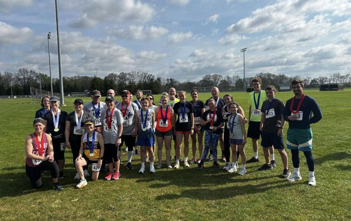 Runners and walkers showing off their medals from the 2024 Three Rivers Promise Run For The Future 5K