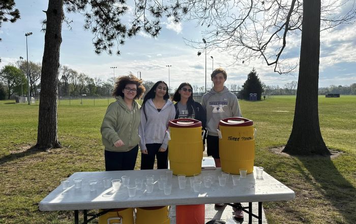 Student volunteers assist with a water station at the Three Rivers Promise Run For The Future 5K event