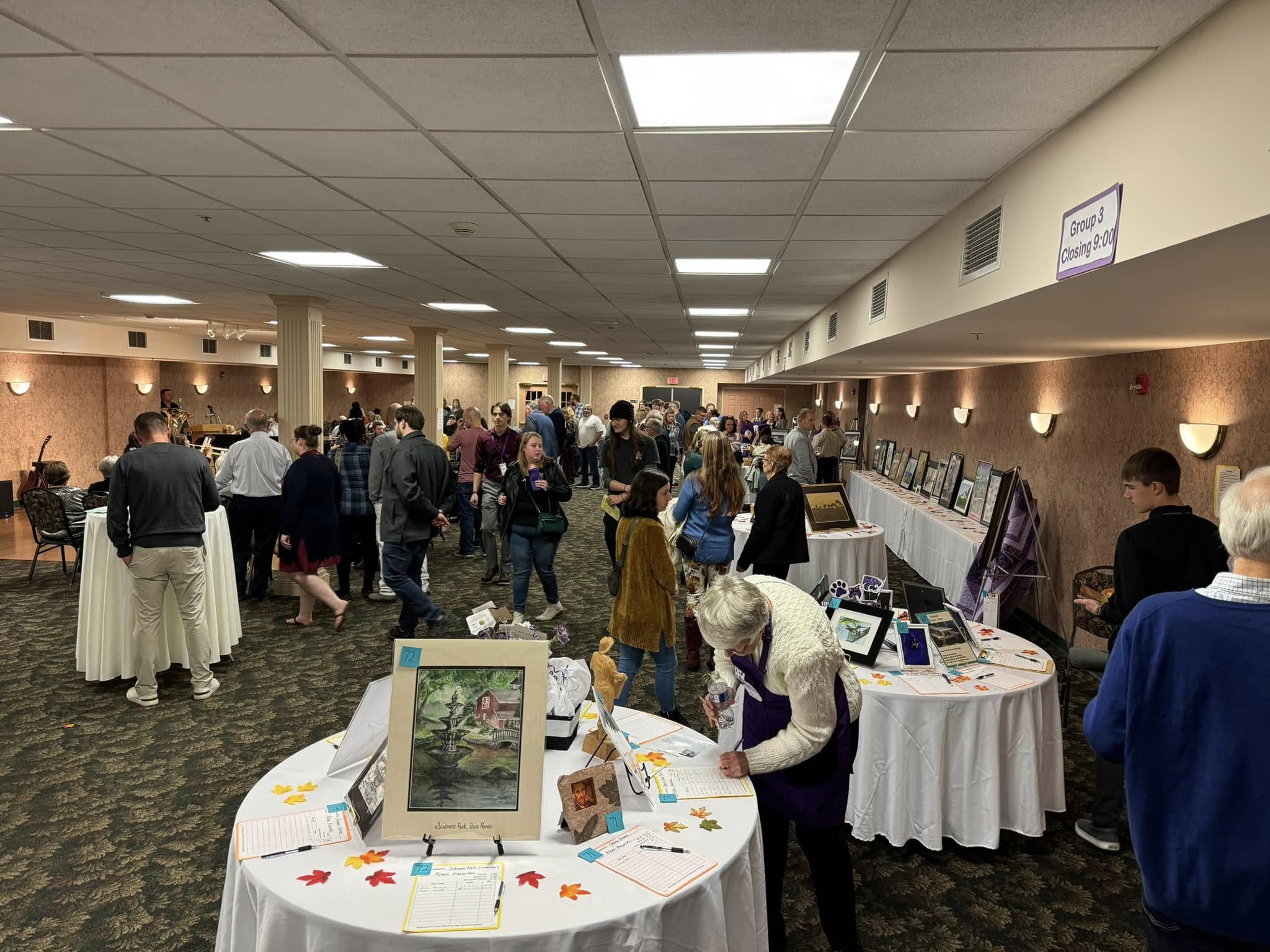 Attendees socialize and bid on the artwork from students and local artists